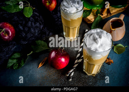 Caramel épicé Apple ou apple pie smoothie, cocktail de fruits d'automne organique avec la crème fouettée, sur un fond sombre, avec les pommes, les feuilles, la sauce au caramel Banque D'Images