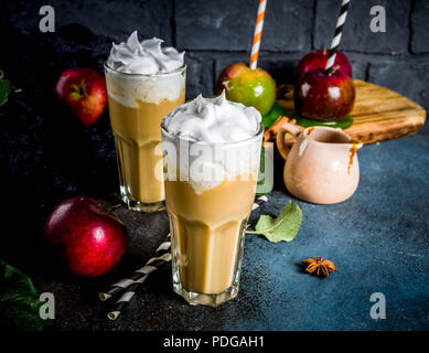 Caramel épicé Apple ou apple pie smoothie, cocktail de fruits d'automne organique avec la crème fouettée, sur un fond sombre, avec les pommes, les feuilles, la sauce au caramel Banque D'Images