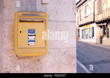 Postbox jaune dans le petit bourg d'Issigeac au sud-ouest de la France d'août 2018. Banque D'Images