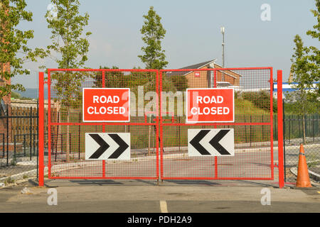 Portes en métal rouge sur une route avec des panneaux route fermée Banque D'Images