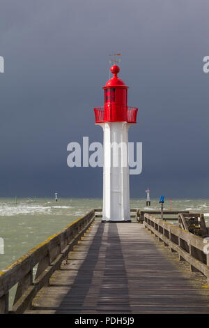 Le phare est peint rouge protégeant le port de Trouville-sur-Mer, Normandie, France avec une tempête venant de derrière Banque D'Images