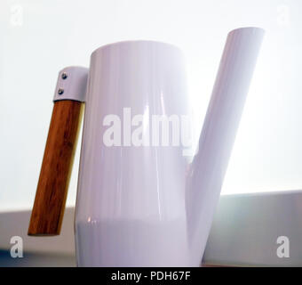 Acier inoxydable blanc verseuse avec poignée en bois. Sur l'arrière-plan de la fenêtre. Banque D'Images