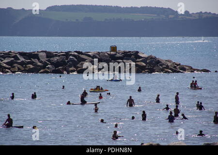 Les gens se rafraîchir et jouer dans la mer à Sidmouth sur une chaude journée d'été. L'est du Devon, Royaume-Uni. Août, 2018. Banque D'Images
