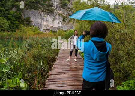 Croatie : les touristes sur une passerelle en bois au parc national des Lacs de Plitvice, l'un des plus anciens parcs nationaux de l'État à la frontière de la Bosnie-Herzegovine Banque D'Images