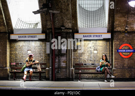 Londres, Royaume-Uni - 08-08-2018 : deux filles assis et attendent leur train à la station de métro Baker Street Banque D'Images