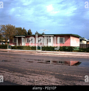 Années 1960, historique, vue extérieure d'un seul étage de couleur rose à l'intérieur de la maison du personnel compond de la gigantesque compagnie pétrolière Aramco (Arabian American Oil Co) à Dhahran, en Arabie Saoudite. Banque D'Images