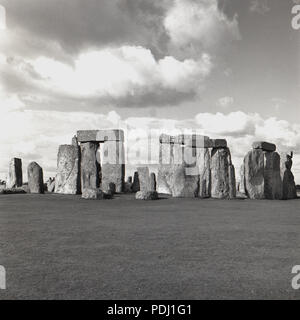 Années 1950, vue de l'antique et mystérieux menhirs préhistoriques à la Stonehenge momument sur Salisbury Plains, Wiltshire, Angleterre, Royaume-Uni. À ce moment les visiteurs pouvaient se promener librement dans le néolithique de pierres, quelque chose qui par la suite n'était pas possible. En 1977, les pierres étaient attachés à pied à cause de la crainte de l'usure et l'érosion. Le nombre de visiteurs ont tellement augmenté - estimé en 2018 à près de 1 millions de dollars - qu'encore plus de restrictions sont maintenant en place. Banque D'Images