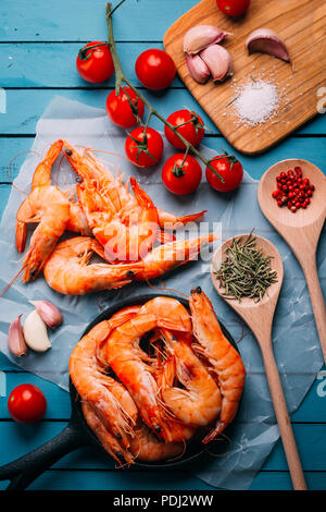 Vue de dessus de table en bois bleu plein de crevettes et quelques ingrédients pour l'assaisonnement et les légumes pour les mélanger, concept de recettes et restaurants Banque D'Images