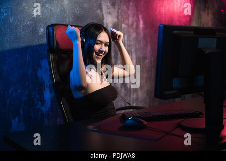 Portrait d'une jeune fille heureuse qui se réjouit après avoir remporté un jeu vidéo, - une célébration qui gagne dans l'émotion de jeu concept. Banque D'Images