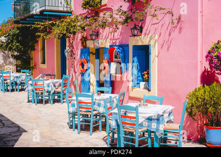 Vivid grec traditionnel de couleur lilas tavern sur l'étroite rue de la Méditerranée sur la chaude journée d'été Banque D'Images