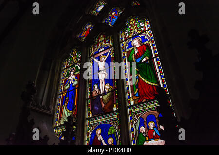 Une tache-fenêtre vitrée représentant la crucifixion de Jésus Christ (conçu par Joseph Bell, 1858), à l'église St Mary, Hopesay, Shropshire, au Royaume-Uni. Banque D'Images