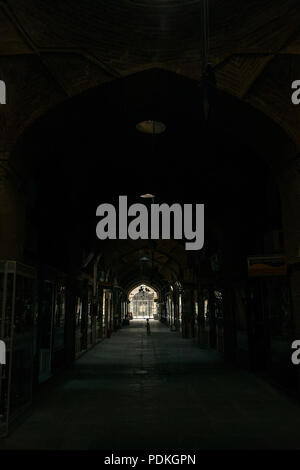 Un vide et sombre couvert fermé grand bazar marché de Isfahan, Iran avec un seul vélo garé en plein milieu. Banque D'Images