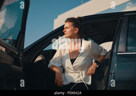 Woman getting down from car Banque D'Images