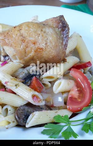 Un repas de Pollo e Penne, ail rôti infusé cuisse de poulet avec des pâtes Penne et tomate, oignons et champignons Banque D'Images