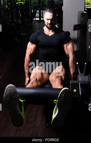 Les jambes Close Up - Homme faisant la jambe avec la machine dans une salle de sport Banque D'Images