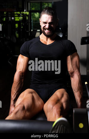 Les jambes Close Up - Homme faisant la jambe avec la machine dans une salle de sport Banque D'Images