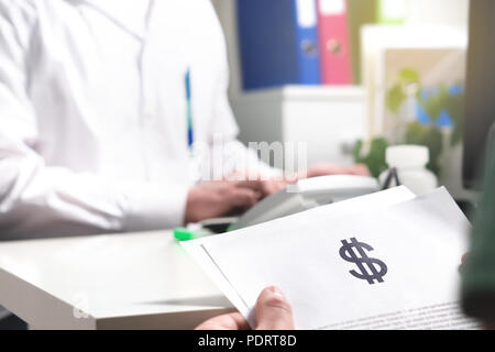 Les prix des soins médicaux et de santé concept. Document papier holding Patient, l'assurance, le projet de loi ou la facture avec le symbole du dollar dans le bureau du médecin à l'hôpital. Banque D'Images