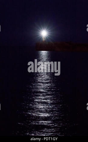 Phare sur Newhaven nuit juillet, avec des réflexions sur l'eau. Banque D'Images