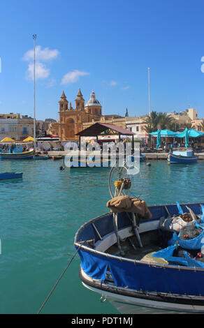 Vue du port de Marsaxlokk, Malte avec un bateau de pêche en premier plan Banque D'Images