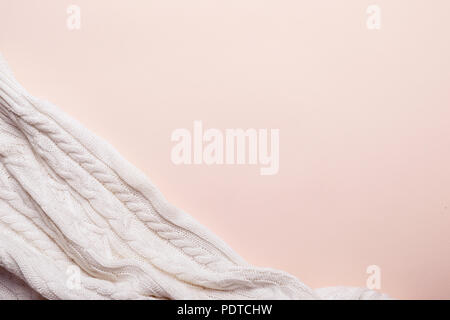 Plaid doux tricoté blanc sur fond rose. romantique chaude prendre soin concept. Banque D'Images