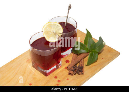 Sirop de groseille rouge dans les verres sur une planche en bois sur un fond blanc et des bâtons de cannelle. Une boisson sucrée. Verre à partir des baies Banque D'Images