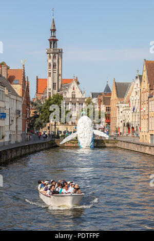 Les touristes dans un canal bateau d'affichage de la baleine en plastique Bruges sculpture réalisée à partir de vieux contenants en plastique et des déchets rejetés par la mer, Banque D'Images