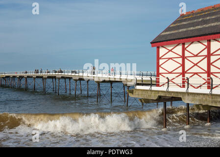 Les personnes bénéficiant d'une promenade le long de l'ancienne jetée à Saltburn-by-the-sea sur la côte de North Yorkshire, Angleterre. Une belle soirée de printemps. Banque D'Images