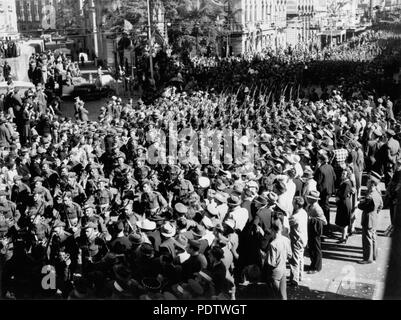 209 1 117172 StateLibQld foules bordent la rue pour regarder la parade de soldats sur Queen Street Brisbane, ca. 1944 Banque D'Images