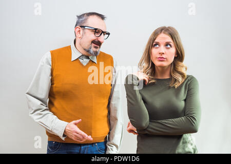 Nerdy man essaie d'obtenir l'attention de belle femme mais elle n'est pas intéressé et en colère de l'ignorer. Banque D'Images