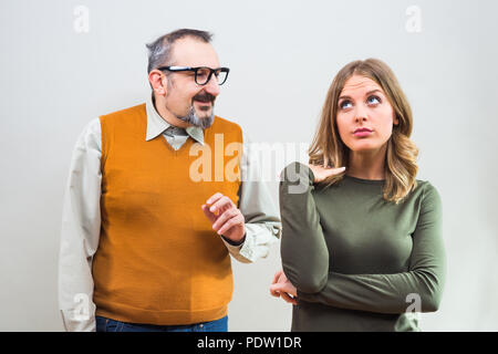 Nerdy man essaie d'obtenir l'attention de belle femme mais elle n'est pas intéressé et en colère de l'ignorer. Banque D'Images