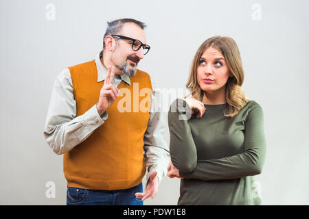 Nerdy man essaie d'obtenir l'attention de belle femme mais elle n'est pas intéressé et en colère de l'ignorer. Banque D'Images