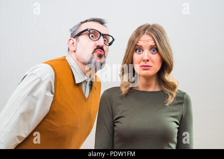 Nerdy man essaie d'obtenir l'attention de belle femme mais elle n'est pas intéressé et désespérément penser le moyen de s'échapper. Banque D'Images