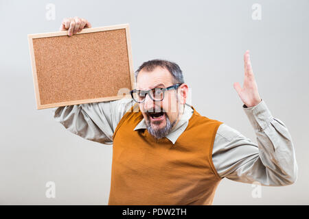 Businessman nerdy est en panique parce que d'une chose tout en maintenant vide panneau de liège. Banque D'Images