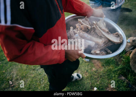 Dans la famille Kirghizistan cuire le dîner à l'extérieur sur feu de bois Banque D'Images