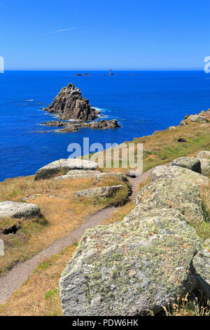 Chevalier armé pile mer et lointain phare drakkars off Land's End de la South West Coast Path, Sennen, Cornwall, England, UK. Banque D'Images