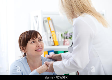 Patient de sexe féminin étant rassurés par Doctor in Hospital Room Banque D'Images