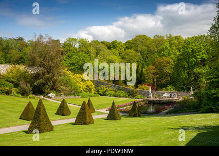 Royaume-uni, Pays de Galles, Anglesey, Plas Cadnant topiaires jardins cachés, pyramides et étang dans jardin clos Banque D'Images