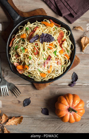 L'automne des pâtes avec du bacon et de citrouille dans poêle en fonte. Spaghetti maison des pâtes au potiron, en l'espace de copie. L'alimentation de l'automne. Banque D'Images