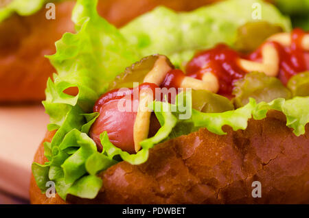 Hot dog avec de la moutarde et du ketchup, gros plan sur un fond de bois Banque D'Images