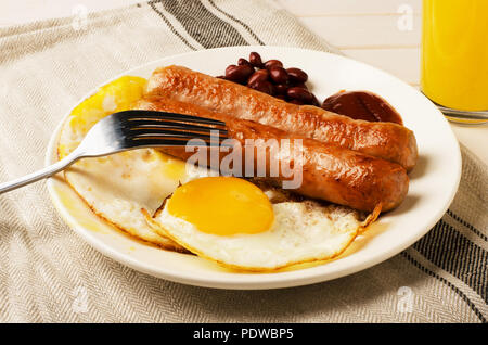 Petit-déjeuner d'œufs au plat et des saucisses avec du jus d'orange Banque D'Images
