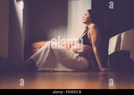 Belles enceintes caucasian woman sitting on the floor et respirer pour se détendre. nouveau concept de vie à la maison Banque D'Images