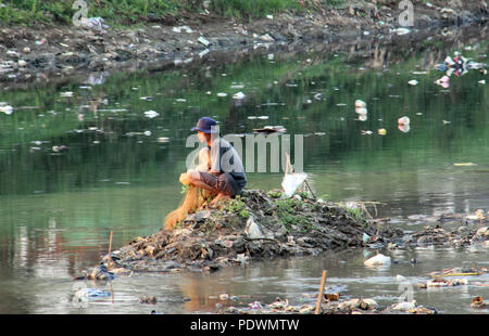 Trouver le poisson des pêcheurs sur la rivière Citarum sale, Bandung, Indonésie. Banque D'Images