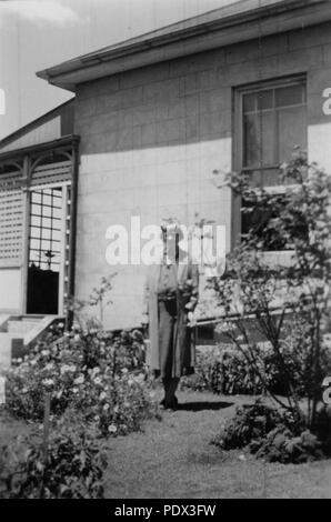 247 1 192831 StateLibQld Lillian Irving debout dans le jardin à Pahroombin, Bowen Hills, ca. 1940 Banque D'Images