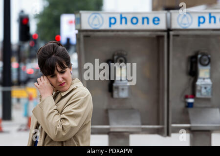 Extra film femme habillée dans le style des années 60, en face de American Vintage Phone Booth pour sa prochaine scène, tourné à Liverpool UK, basée sur Washington DC USA Banque D'Images