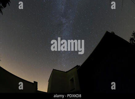 Sablet, Provence-Alpes-Côte d'Azur, France. 11 août, 2018. Deux météores des Perséides traversent la Voie lactée au-dessus du bâti, vu d'un ciel sombre au-dessus d'un toit de maison de village dans les premières heures du 11 août. Les météores des Perséides est due à pic sur les nuits des 11, 12 et 13 août. Credit : Malcolm Park/Alamy Live News. Banque D'Images