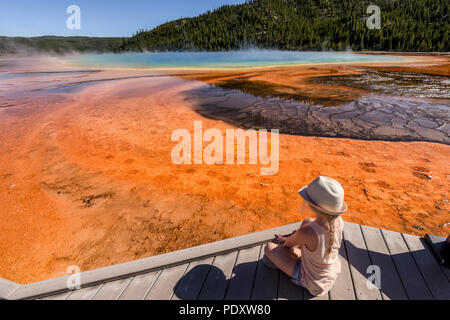 Une petite fille d'admirer les couleurs chatoyantes du Grand Prismatic Spring, Midway Geyser Basin, Parc National de Yellowstone Banque D'Images