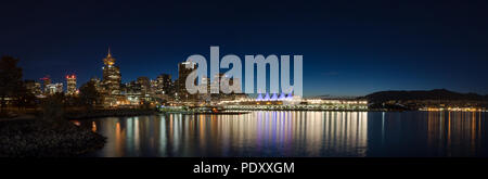 VANCOUVER, BC, CANADA - SEPT 12, 2015 : le centre-ville de Vancouver et la Place du Canada, dans la nuit, avec les montagnes de la rive nord à l'arrière-plan. Banque D'Images