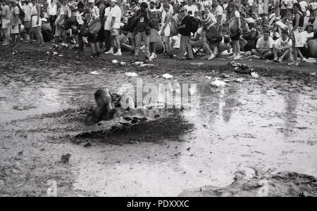Young Adult Man coulissant dans la boue pendant le Festival de musique de Woodstock, Saugerties, New York, USA, 13 juillet 1994 Banque D'Images