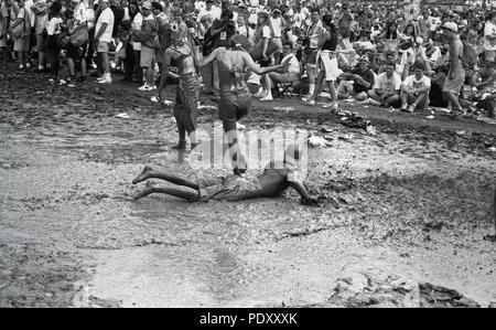 Trois personnes dans la boue pendant le Festival de musique de Woodstock, Saugerties, New York, USA, 13 juillet 1994 Banque D'Images