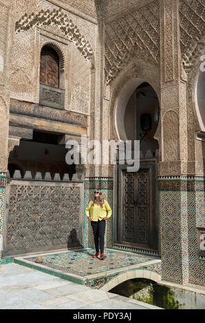 Tourist dans la cour, Madrasa Bou Inania medersa, l'arabe, l'ornementation, Fes, Maroc Banque D'Images